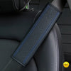 A close-up of a black PU leather embossed seat belt shoulder cushion with blue stitching on a vehicle seat.