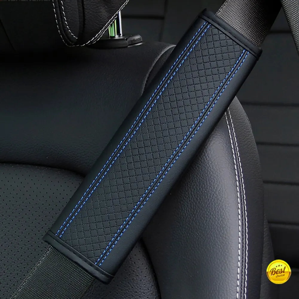 A close-up of a black PU leather embossed seat belt shoulder cushion with blue stitching on a vehicle seat.