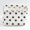 A white cotton and linen storage basket with black polka dots, shown from the front.