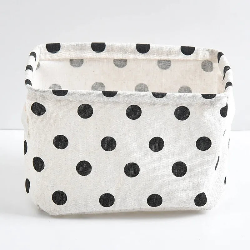 A white cotton and linen storage basket with black polka dots, shown from the front.