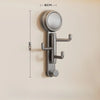 A silver, rotatable suction cup hook with a circular head and mounting bracket is shown against a light wall.