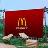 Grande bannière rouge avec le logo McDonald's et le texte I'm lovin' it, affichée à l'extérieur.