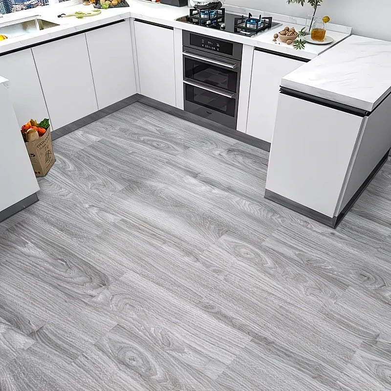 Light gray wood grain floor tiles installed in a modern kitchen setting.