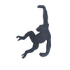 A black monkey-shaped wooden wall hook for keys and decor.