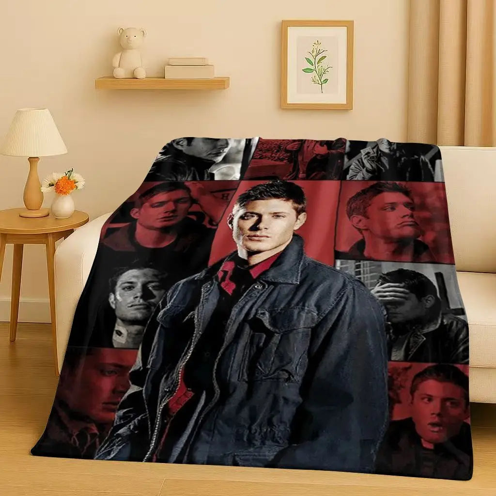 A dark flannel throw blanket featuring multiple portraits of characters from the Supernatural TV show
