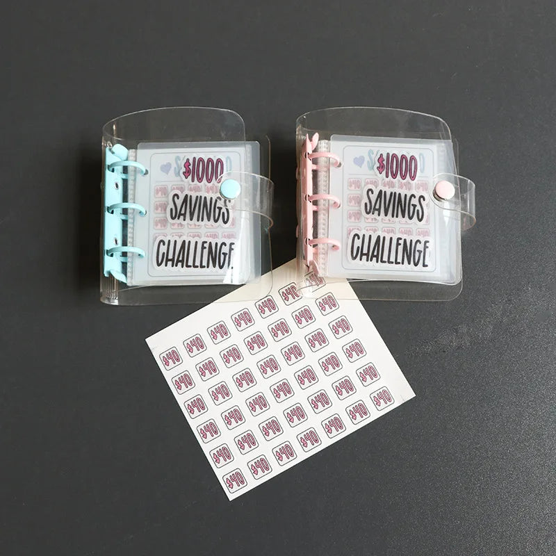 Zwei klare Kunststoffbinder für eine Spar-Challenge, einer rosa und einer türkis, mit einem Blatt Spar-Challenge-Karten