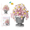 A set of pink and yellow flower building blocks featuring roses, sunflowers, and carnations in a gray pot.
