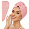 A woman is wearing a pink microfiber hair drying towel wrap on her head.