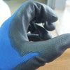 A hand wearing black and blue breathable PU-coated work gloves, showing the grip texture.