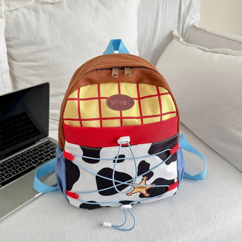 A brown and yellow cow print backpack with blue straps resting on a white surface.