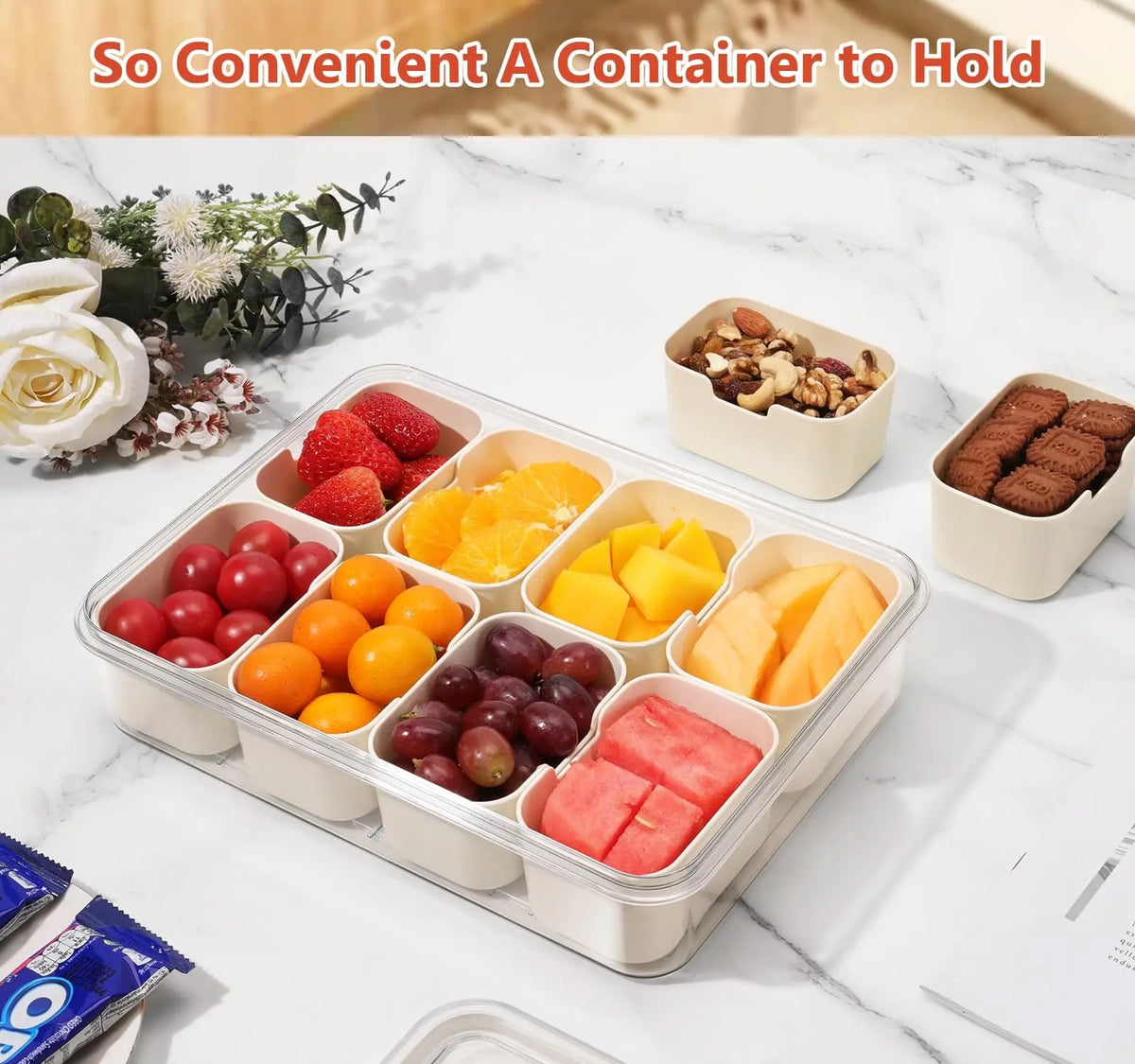 An 8-compartment portable snack box filled with various fresh fruits like strawberries, oranges, grapes, and mango slices.