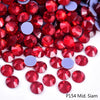 A close-up view of red and purple rhinestones scattered on a white background.