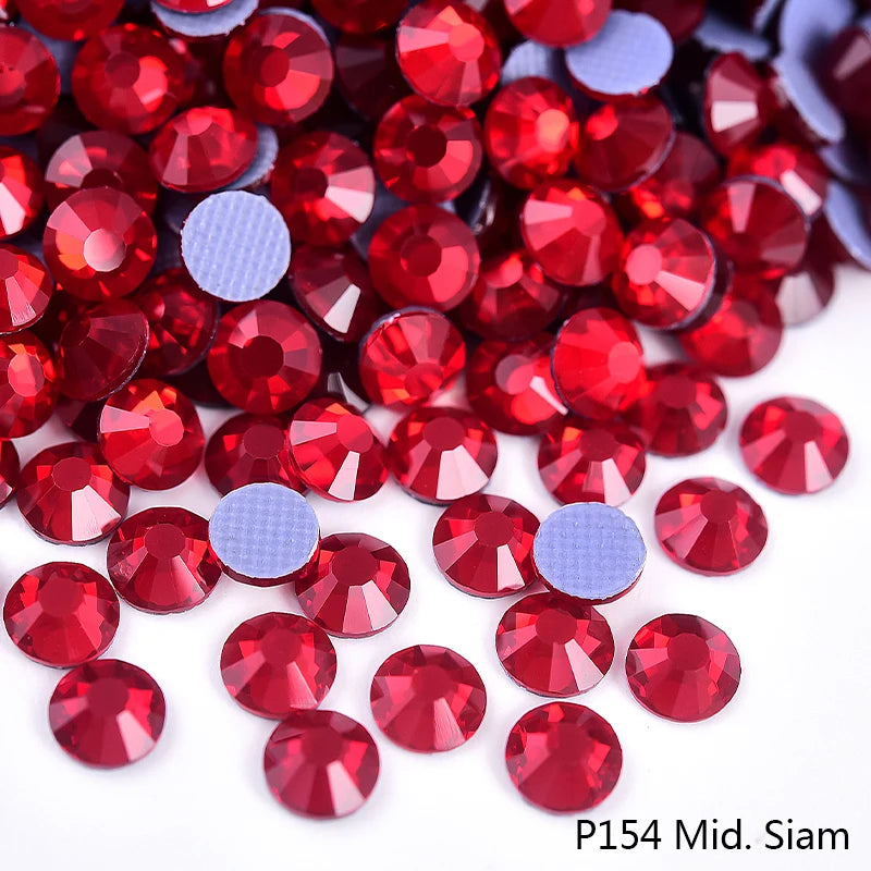 A close-up view of red and purple rhinestones scattered on a white background.