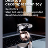 A polished silver magnetic levitating spinning top toy resting on a dark laptop surface.