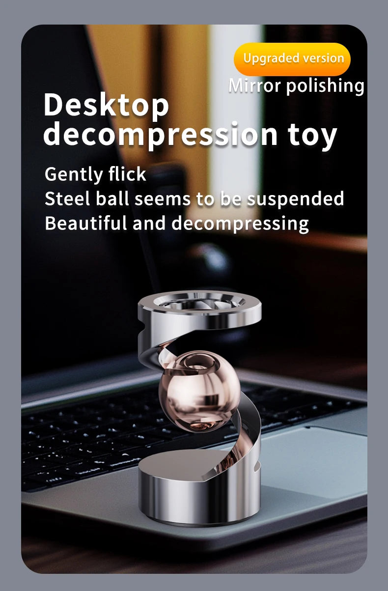 A polished silver magnetic levitating spinning top toy resting on a dark laptop surface.