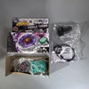 A set of metal spinning tops including a large purple top, a green top, and accessories in packaging.