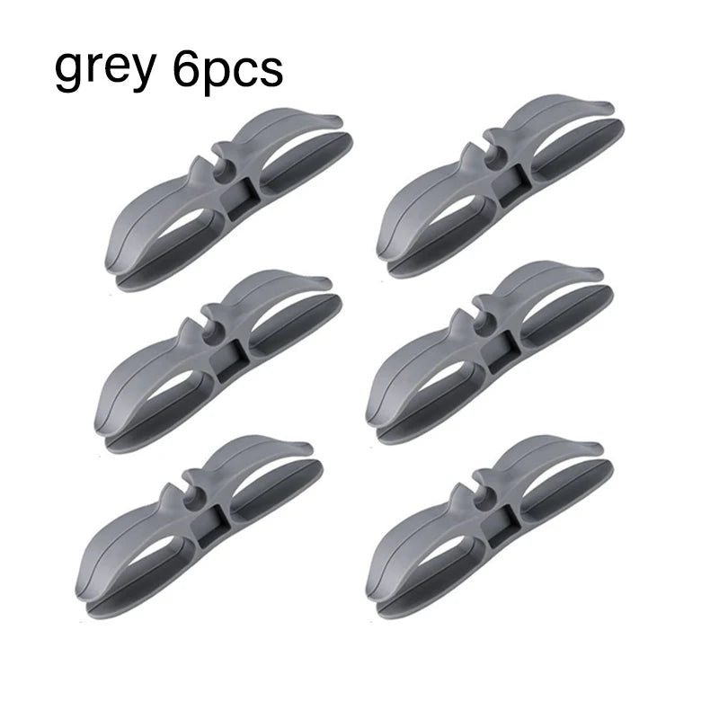 Six grey cord organizers or wire winders for tidy cable management.