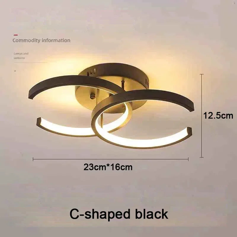 C-shaped black LED ceiling light fixture with a circular diffuser and warm glow.