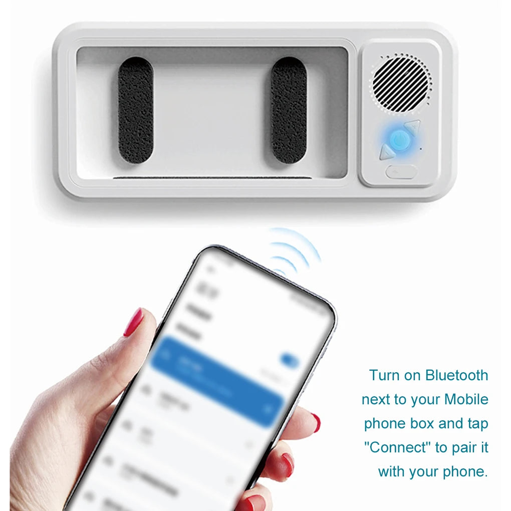 A white waterproof shower phone holder with two speaker holes and a Bluetooth connection icon is shown next to a smartphone.