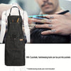 A dark gray multi-pocket denim and waxed canvas work apron being held by a person with a mustache.