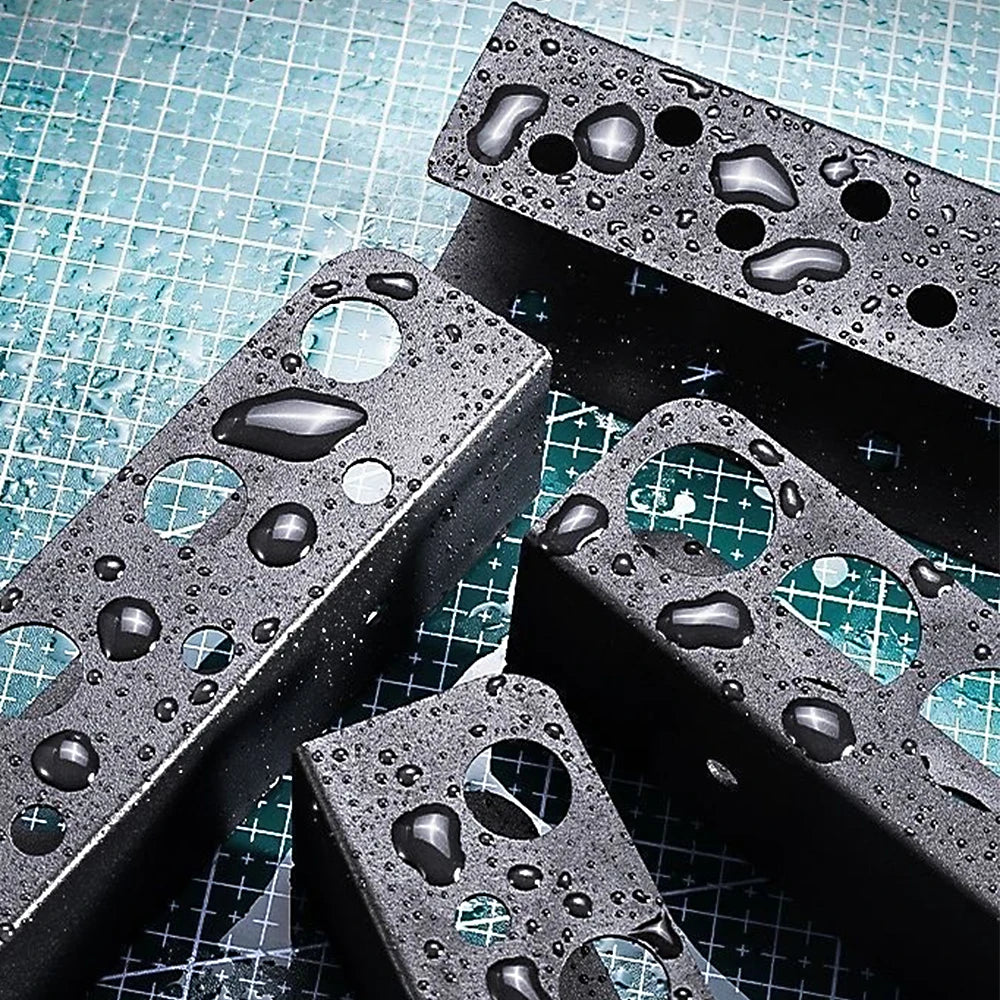 A black heavy-duty wall mounted tool storage rack with holes, covered in water droplets, resting on a blue grid surface.