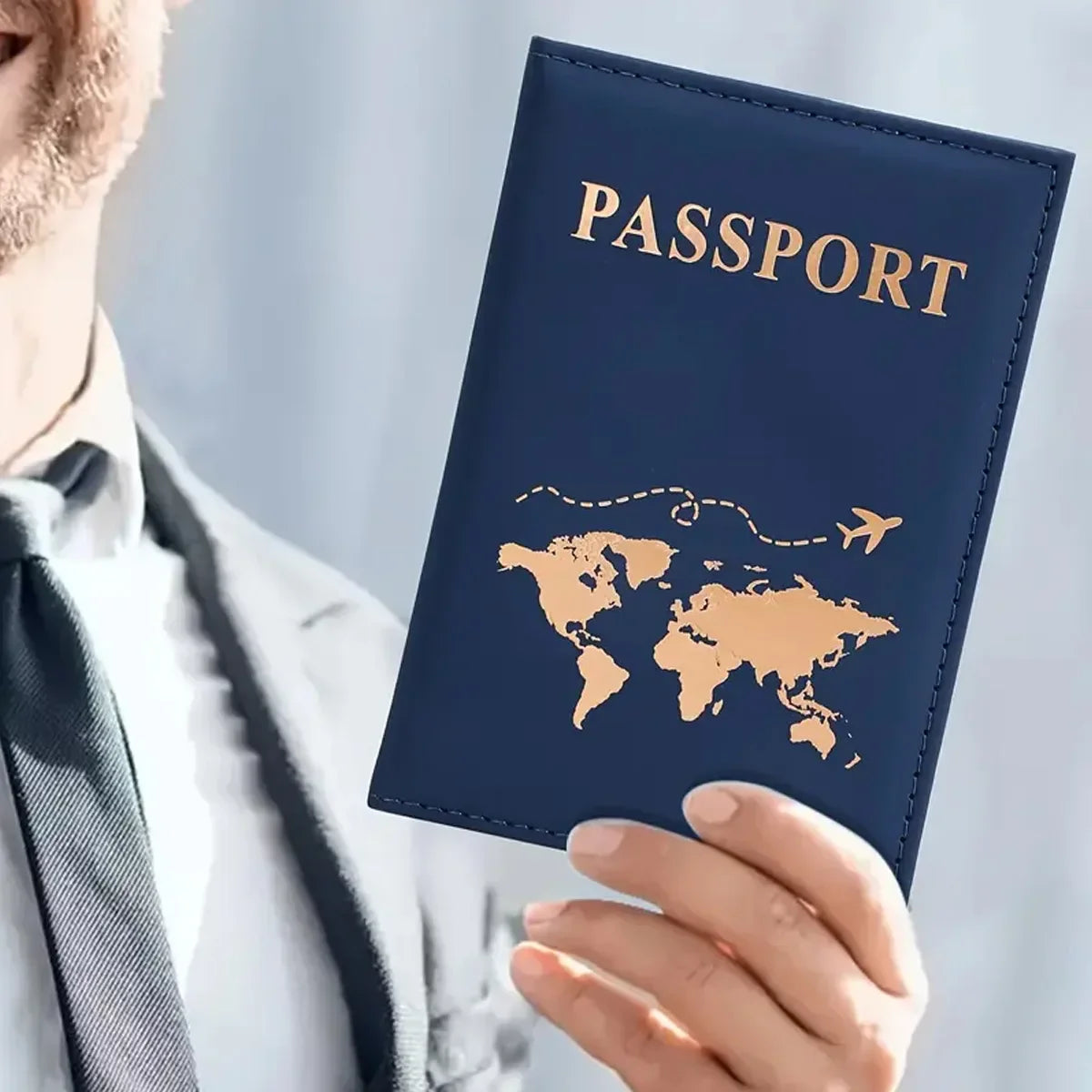 Dunkelblaue Lederhülle für Reisepass mit goldfarbiger Gravur einer Weltkarte und dem Wort PASSPORT.