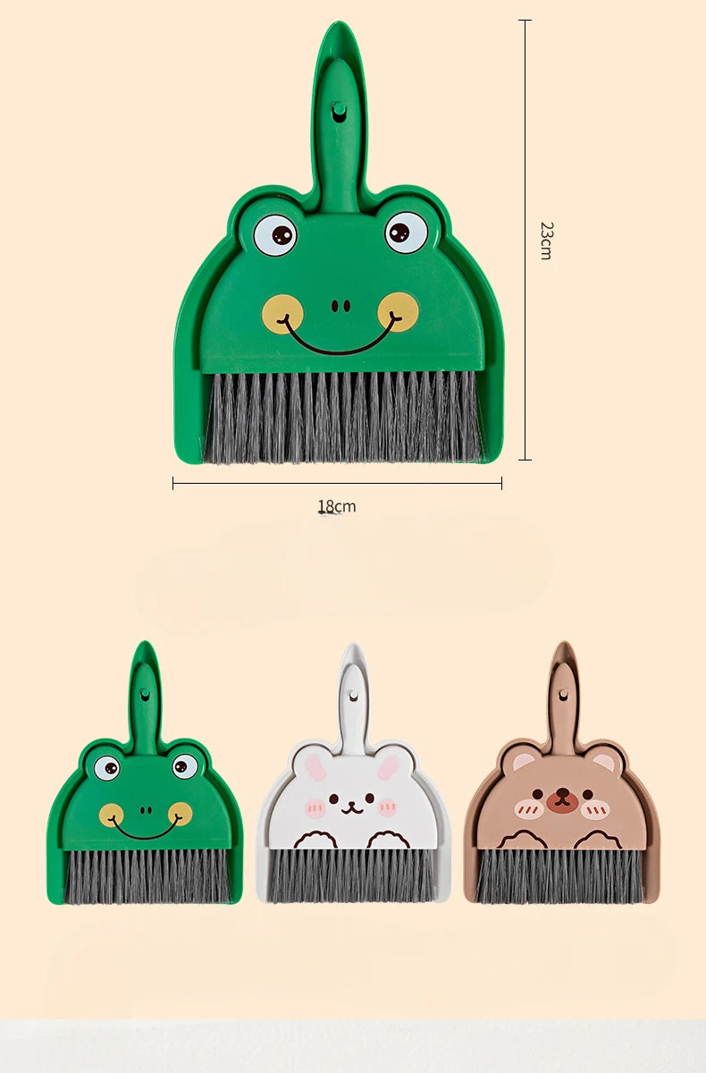 A set of three compact cartoon brooms and dustpans in green, pink, and brown for tabletop cleaning.