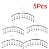 Five pieces of black metal pant hangers with individual clips.