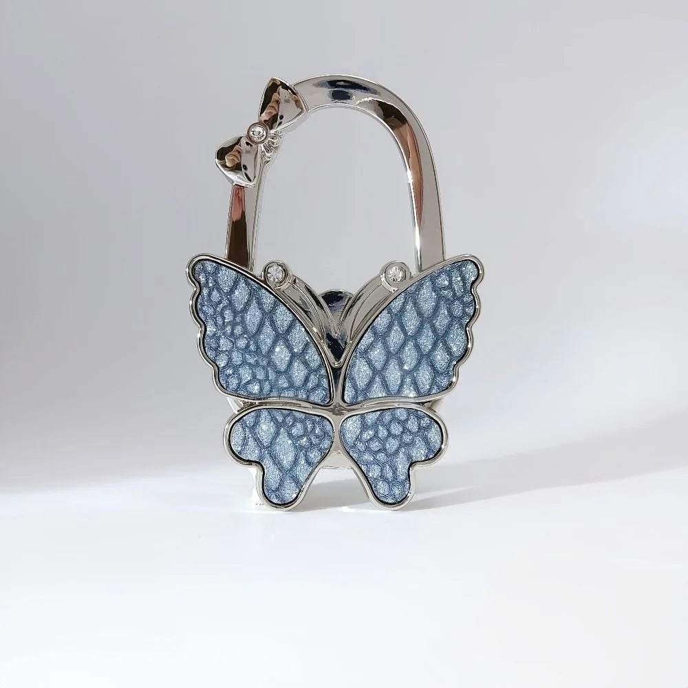 Silver foldable butterfly shaped handbag hook with detailed texture