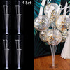 A set of four clear plastic balloon column stands for party decor displayed against a dark background.