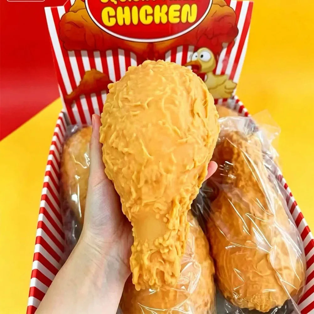 Eine Hand hält ein realistisches Spielzeug, das eine frittierte Hähnchenkeule in seiner Verpackung simuliert.