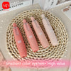 A set of four pink retractable roller pens with a gradient color system displayed on a woven mat.