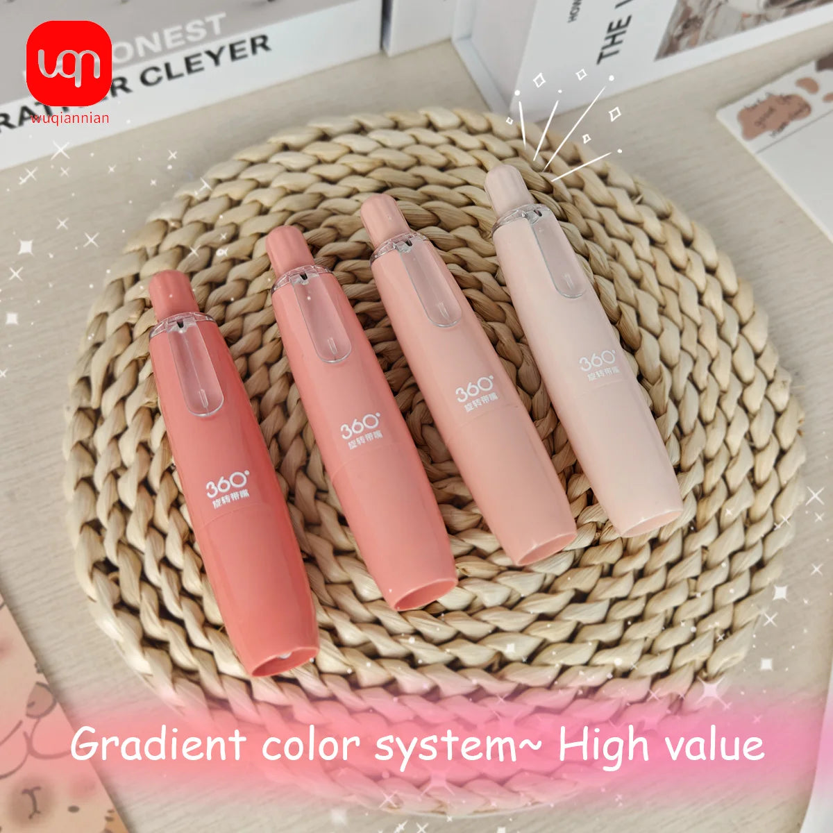 A set of four pink retractable roller pens with a gradient color system displayed on a woven mat.