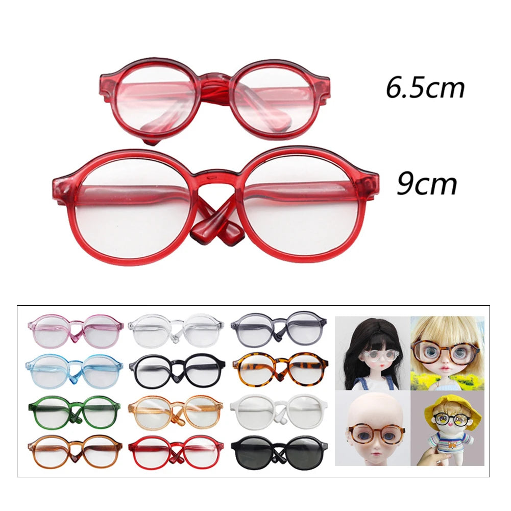 A collection of transparent plastic sunglasses for dolls in various styles and sizes.