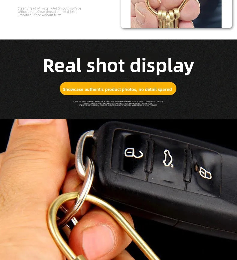 A hand holds a gold brass keychain with a locking carabiner clip.