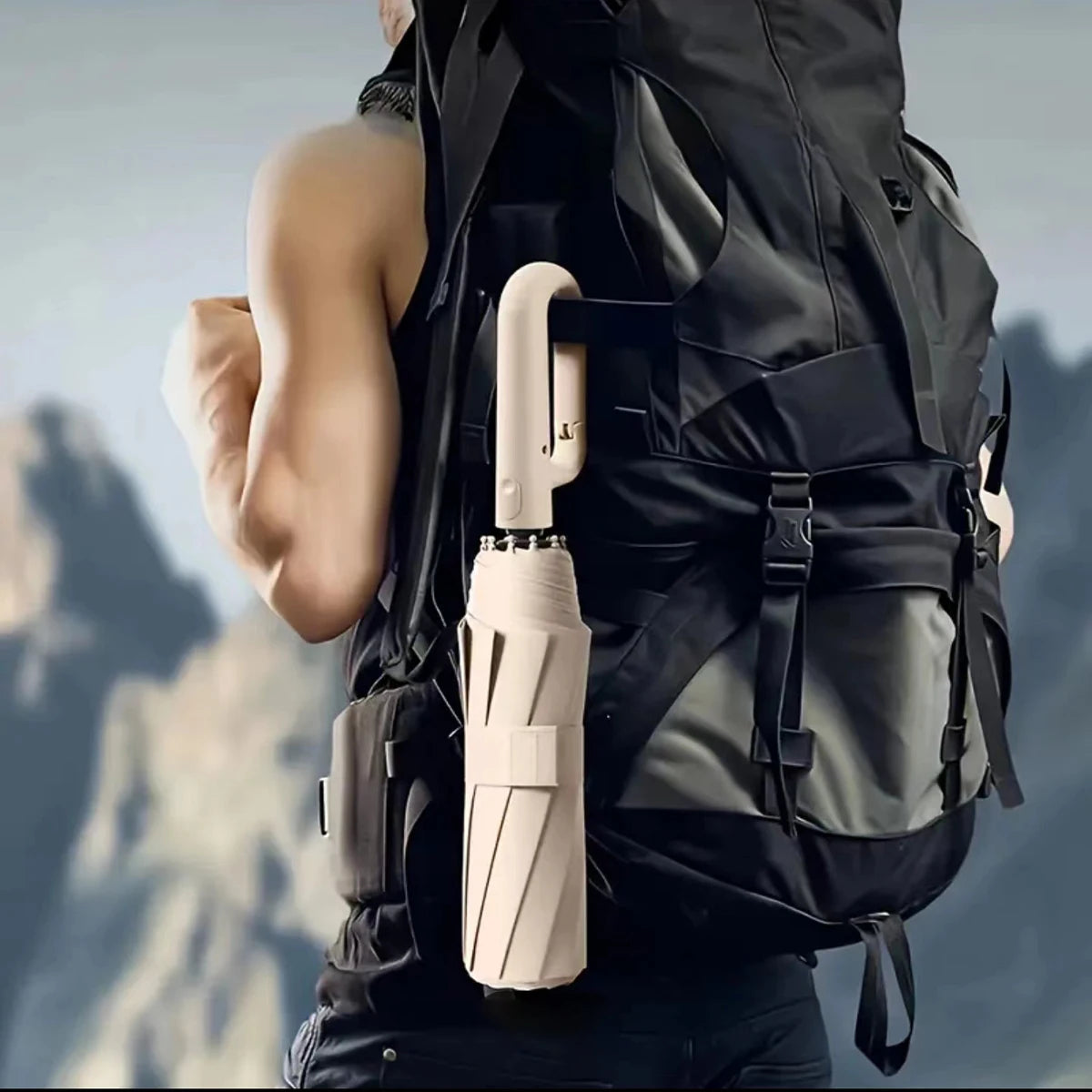 Beige zusammenfaltbarer Regenschirm befestigt an einem schwarzen Rucksack.