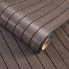 Roll of brown wood grain peel-and-stick wallpaper featuring a vertical stripe pattern.