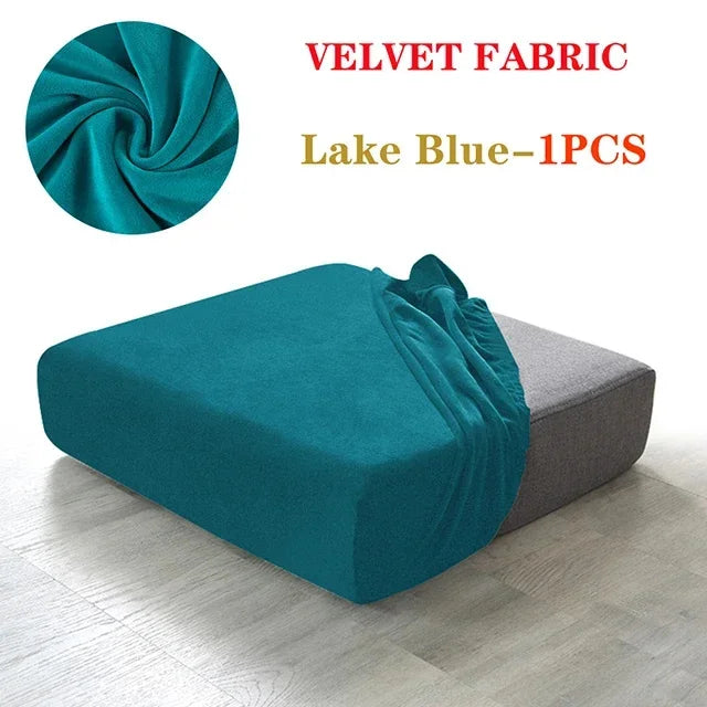 A teal velvet fabric sofa cover displayed on a modern gray sofa, showing the texture and drape of the fabric.