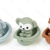 Three soft silicone sensory bath toys shaped like animals in different shades of gray, green, and brown.