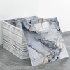 Rolls of peel-and-stick marble wall tiles featuring gray and black marble patterns with gold accents