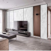 Modern kitchen design featuring a large television mounted above a dark cabinet and marble-patterned wall panels.