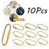 A set of ten gold brass keychain charms with locking carabiner clips shown in various angles.