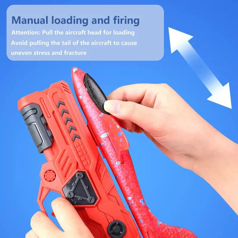 A hand is manually loading and firing an orange foam glider plane launcher toy for kids.