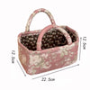 A pink quilted fabric storage basket with a handle and a patterned lining, shown from above.