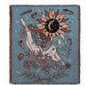 A teal woven blanket featuring a large sun design with radiating rays and surrounding floral and leaf elements.