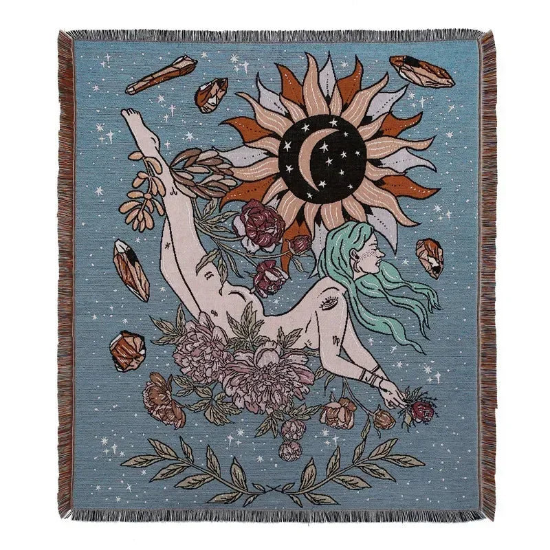 A teal woven blanket featuring a large sun design with radiating rays and surrounding floral and leaf elements.