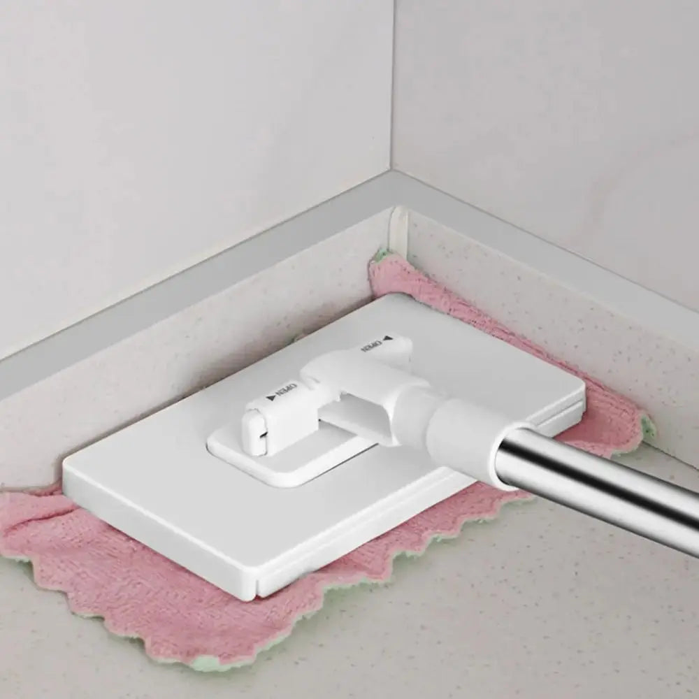A white 360° rotating hands-free flat mop with a reusable cloth resting on a pink towel.