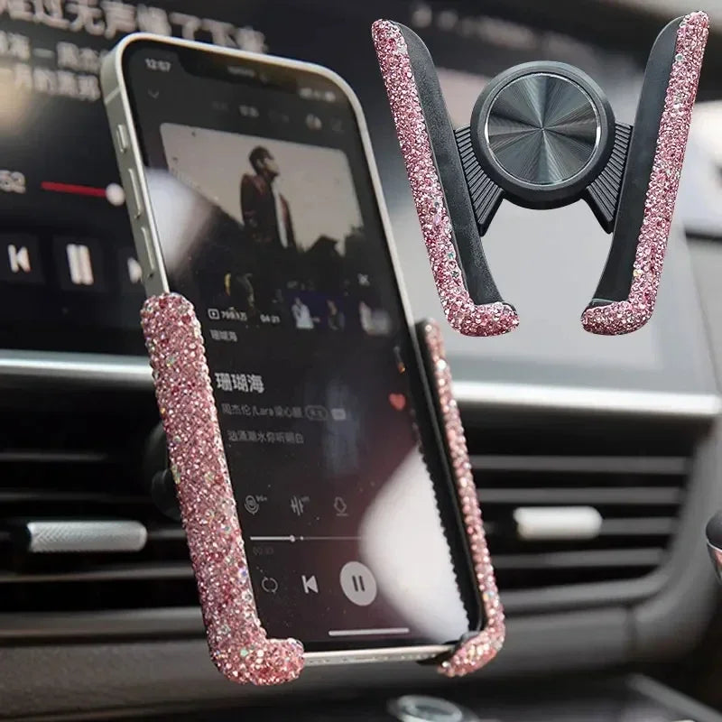 A crystal pink car phone holder with a vent mount is shown attached to a smartphone inside a car dashboard.