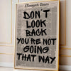 Framed canvas wall art featuring a black and white newspaper-style quote that reads Don't look back you're not going that way