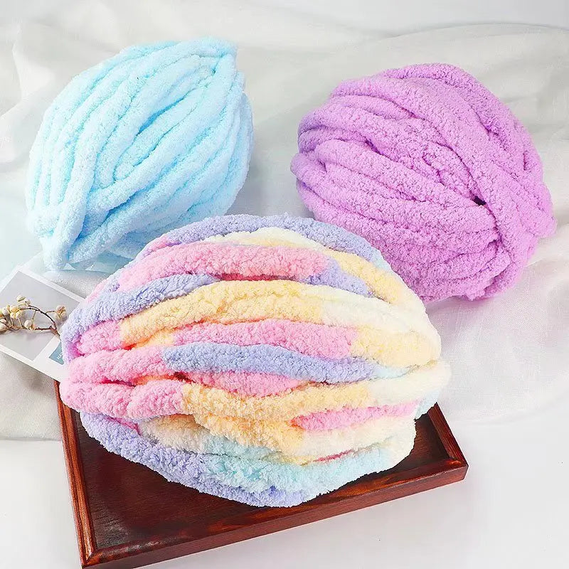 Three skeins of brightly colored extra thick chenille yarn including blue, purple, and yellow shades